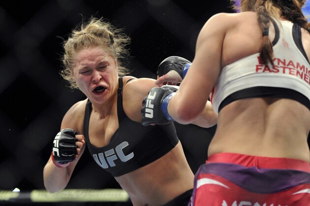 FILE - In this Dec. 28, 2013, file photo, Ronda Rousey, left, of Venice, Calif., punches Miesha Tate of Yakima, Wash., during the UFC 168 mixed martial arts women's bantamweight title fight in Las Vegas. Rousey's star power grows with each month, and the UFC's dominant bantamweight champion could have held her next title defense anywhere. She chose to travel to Bethe Correia's native Brazil for UFC 190 on Saturday, Aug. 1,  just so she can embarrass the challenger in front of her home fans. (AP Photo/David Becker, File)