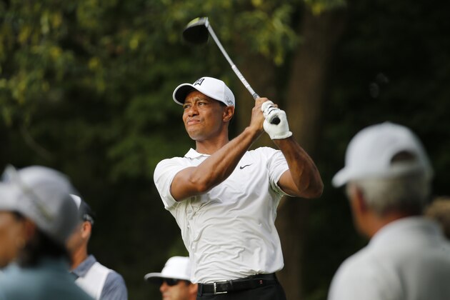 Tiger Woods watches his tee shot on the 18th hole during the first round of the Quicken Loans National golf tournament at the Robert Trent Jones Golf Club in Gainesville, Va., Thursday, July 30, 2015. (AP Photo/Steve Helber)
