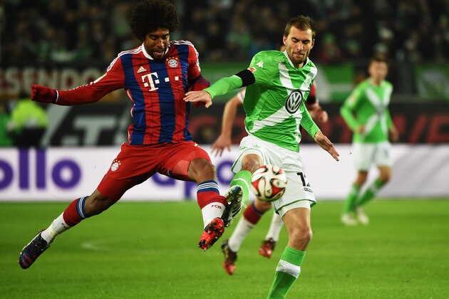 WOLFSBURG, GERMANY - JANUARY 30:  Dante of Muenchen is challenged by Bas Dost of Wolfsburg during the Bundesliga match between VfL Wolfsburg and FC Bayern Muenchen at Volkswagen Arena on January 30, 2015 in Wolfsburg, Germany.  (Photo by Stuart Franklin/Getty Images for MAN)