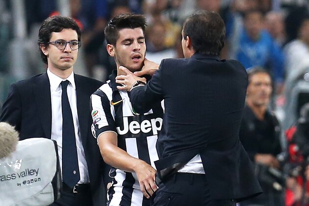 Juventus' forward Alvaro Morata of Spain is stopped by Juventus' coach Massimiliano Allegri during the Italian Serie A football match Juventus Vs AS Roma on October 5, 2014 at Juventus  Stadium in Turin.  AFP PHOTO / MARCO BERTORELLO        (Photo credit should read MARCO BERTORELLO/AFP/Getty Images)