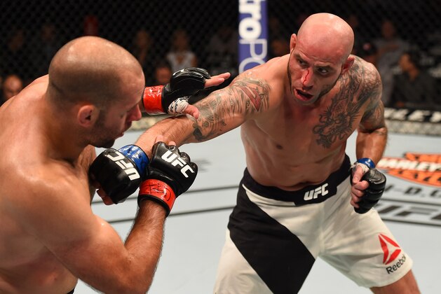 CHICAGO, IL - JULY 25:   (R-L) Ben Saunders punches Kenny Robertson in their welterweight bout during the UFC event at the United Center on July 25, 2015 in Chicago, Illinois. (Photo by Jeff Bottari/Zuffa LLC/Zuffa LLC via Getty Images)