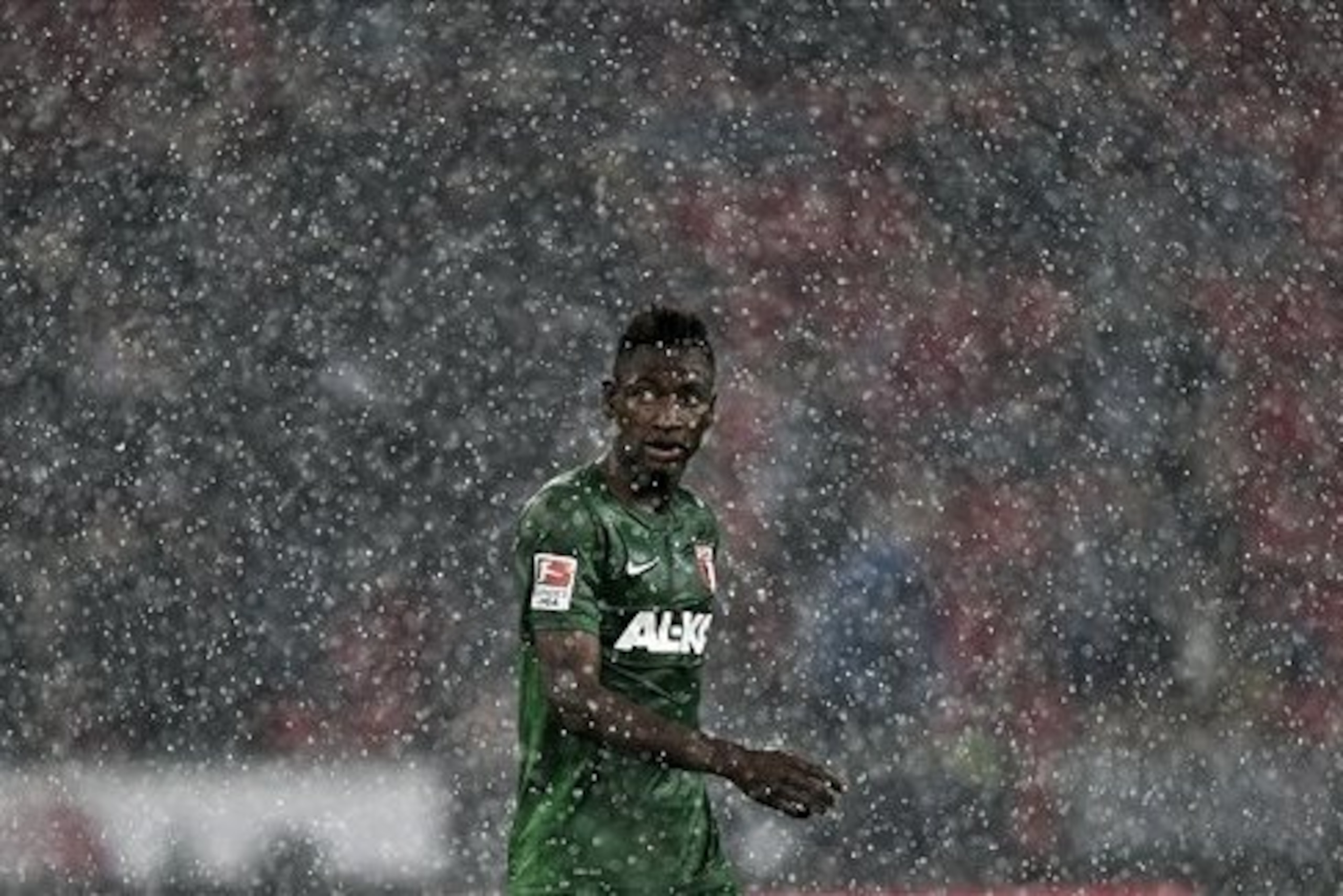 Augsburg's Abdul Rahman Baba from Ghana leaves the pitch after the match was interrupted because of heavy rain and lightning, during the German Bundesliga soccer match between Bayer Leverkusen and FC Augsburg in Leverkusen  Germany, Wednesday, Sept. 24, 2014. (AP Photo/Martin Meissner)
