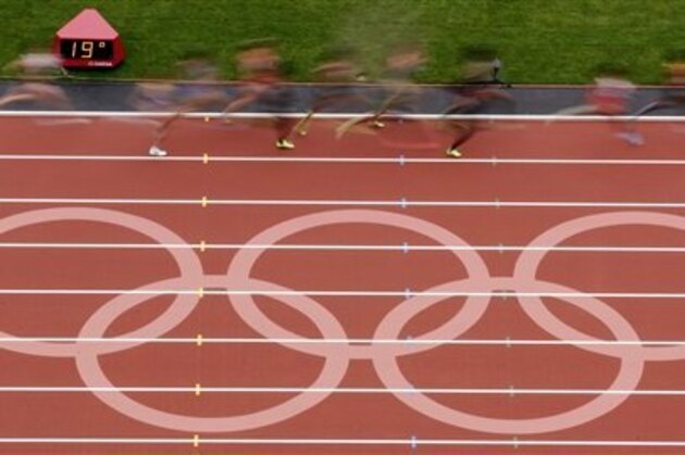 Runners make their way past a logo on the track during a women's 5000-meter heat at athletics in the Olympic Stadium at the 2012 Summer Olympics, London, Tuesday, Aug. 7, 2012. (AP Photo/Morry Gash)