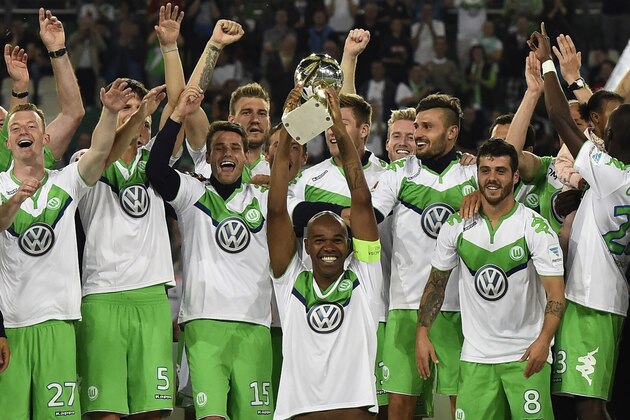 Wolfsburg's Brazilian defender Naldo (C) holds the trophy and celebrates with Wolfsburg's players and Wolfsburg's head coach Dieter Hecking (R) after winning the German Supercup football match VfL Wolfsburg vs Bayern Munich in Wolfsburg, central Germany, on August 1, 2015. Wolfsburg wins 5-4. AFP PHOTO / TOBIAS SCHWARZ   ALTERNATIVE CROP

DFL RULES TO LIMIT THE ONLINE USAGE DURING MATCH TIME TO 15 PICTURES PER MATCH. IMAGE SEQUENCES TO SIMULATE VIDEO IS NOT ALLOWED AT ANY TIME. FOR FURTHER QUERIES PLEASE CONTACT DFL DIRECTLY AT + 49 69 650050.        (Photo credit should read TOBIAS SCHWARZ/AFP/Getty Images)