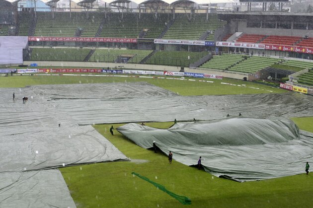 Bangladeshi groundstaff cover the field as rain falls during the fourth day of the second cricket Test match between Bangladesh and South Africa at the Sher-e-Bangla National Cricket Stadium in Dhaka on August 2, 2015. Rain has washed out the play for third successive day in the second and final Test between Bangladesh and South Africa at the Sher-e-Bangla stadium in Dhaka.    AFP PHOTO/ Munir uz ZAMAN        (Photo credit should read MUNIR UZ ZAMAN/AFP/Getty Images)