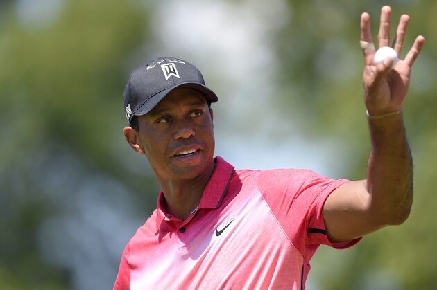 Tiger Woods waves to the gallery on the 15th green during the final round of the Quicken Loans National golf tournament at the Robert Trent Jones Golf Club in Gainesville, Va., Sunday, Aug. 2, 2015. (AP Photo/Nick Wass)