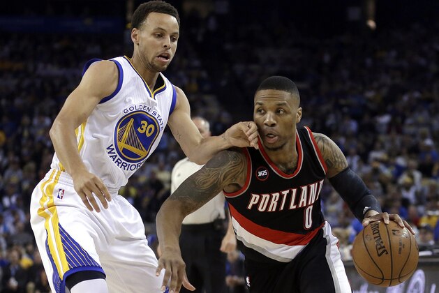 Portland Trail Blazers' Damian Lillard, right, drives the ball against Golden State Warriors' Stephen Curry during the first half of an NBA basketball game Thursday, April 9, 2015, in Oakland, Calif. (AP Photo/Ben Margot)