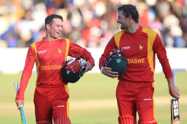 Zimbabwean batsmen Sean Williams, left, and Craig Ervine walk off the pitch after beating New Zealand during the One Day International Cricket match  in Harare, Sunday, Aug. 2, 2015.(AP Photo/Tsvangirayi Mukwazhi)