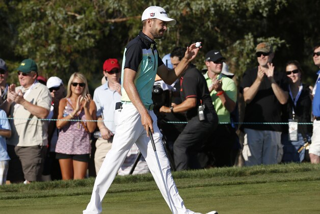 Troy Merritt tips the ball to the crowd after a birdie on the 16th hole during the final round of the Quicken Loans National golf tournament at the Robert Trent Jones Golf Club in Gainesville, Va., Sunday, Aug. 2, 2015. Merritt won the tournament at 18-under-par.  (AP Photo/Steve Helber)