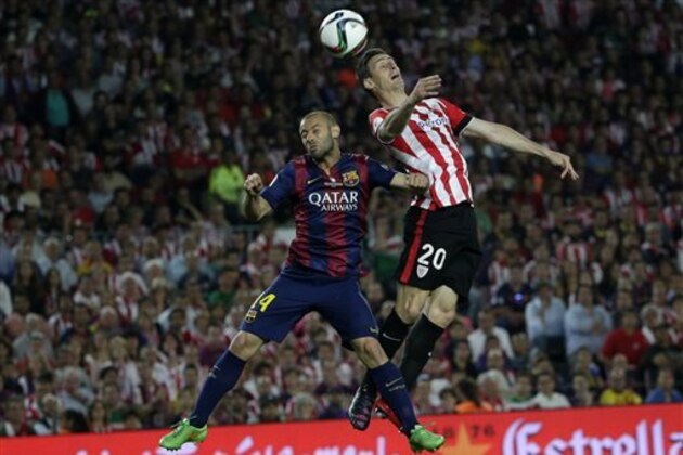 Barcelona's Javier Mascherano, left and Athletic Bilbao's Aritz Aduriz jump for a high ball during the final of the Copa del Rey soccer match between FC Barcelona and Athletic Bilbao at the Camp Nou stadium in Barcelona, Spain, Saturday, May 30, 2015. (AP Photo/Emilio Morenatti)