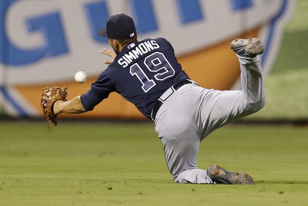 Atlanta Braves shortstop Andrelton Simmons goes flying after the ball during the seventh inning of a baseball game against the Philadelphia Phillies, Saturday, Aug. 1, 2015, in Philadelphia. The Phillies won 12-2. (AP Photo/Chris Szagola)