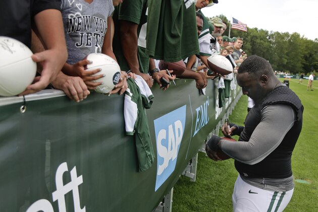 New York Jets defensive end Muhammad Wilkerson signs autographs for fans after practice at the team's NFL football training camp, Saturday, Aug. 1, 2015, in Florham Park, N.J.. (AP Photo/Julie Jacobson)