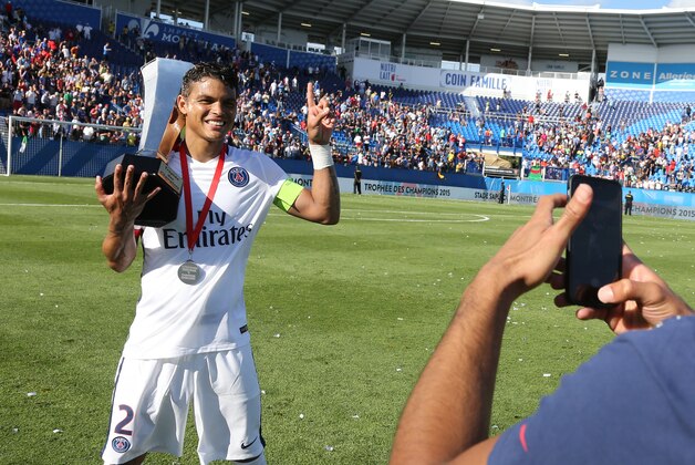 MONTREAL, QC  - AUGUST 1: Thiago Silva of PSG poses with trophy for a picture taken by teammate Lucas Moura of PSG after winning the 2015 Trophee des Champions between Paris Saint-Germain (PSG) and Olympique Lyonnais (OL) at Stade Saputo on August 1, 2015 in Montreal, Quebec, Canada. (Photo by Jean Catuffe/Getty Images)