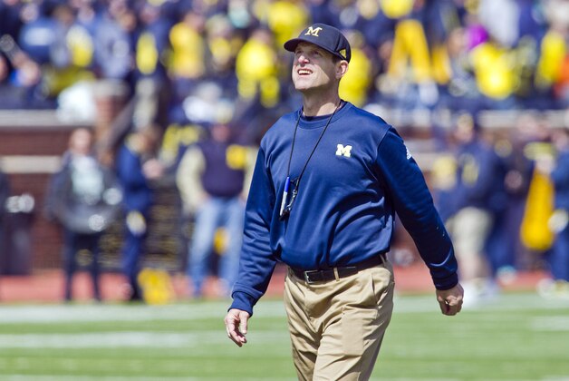 Michigan head coach Jim Harbaugh walks the field between downs during the NCAA college football team's spring game in Ann Arbor, Mich., Saturday, April 4, 2015. (AP Photo/Tony Ding)