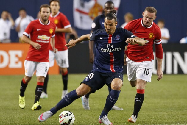 Paris Saint-Germain forward Zlatan Ibrahimovic, left, keeps the ball away from Manchester United forward Wayne Rooney, right, in the first half of an International Champions Cup soccer match, Wednesday, July 29, 2015, in Chicago. (AP Photo/Kamil Krzaczynski)