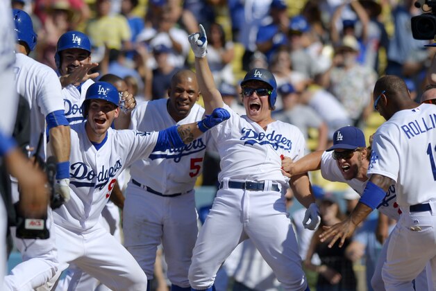 Members of the Los Angeles Dodgers wait at home plate for Andre Ethier, left, after Ethier hit a two-run home run to win the game in the 10th inning of a baseball game against the Los Angeles Angels, Sunday, Aug. 2, 2015, in Los Angeles. The Dodgers won 5-3. (AP Photo/Mark J. Terrill)