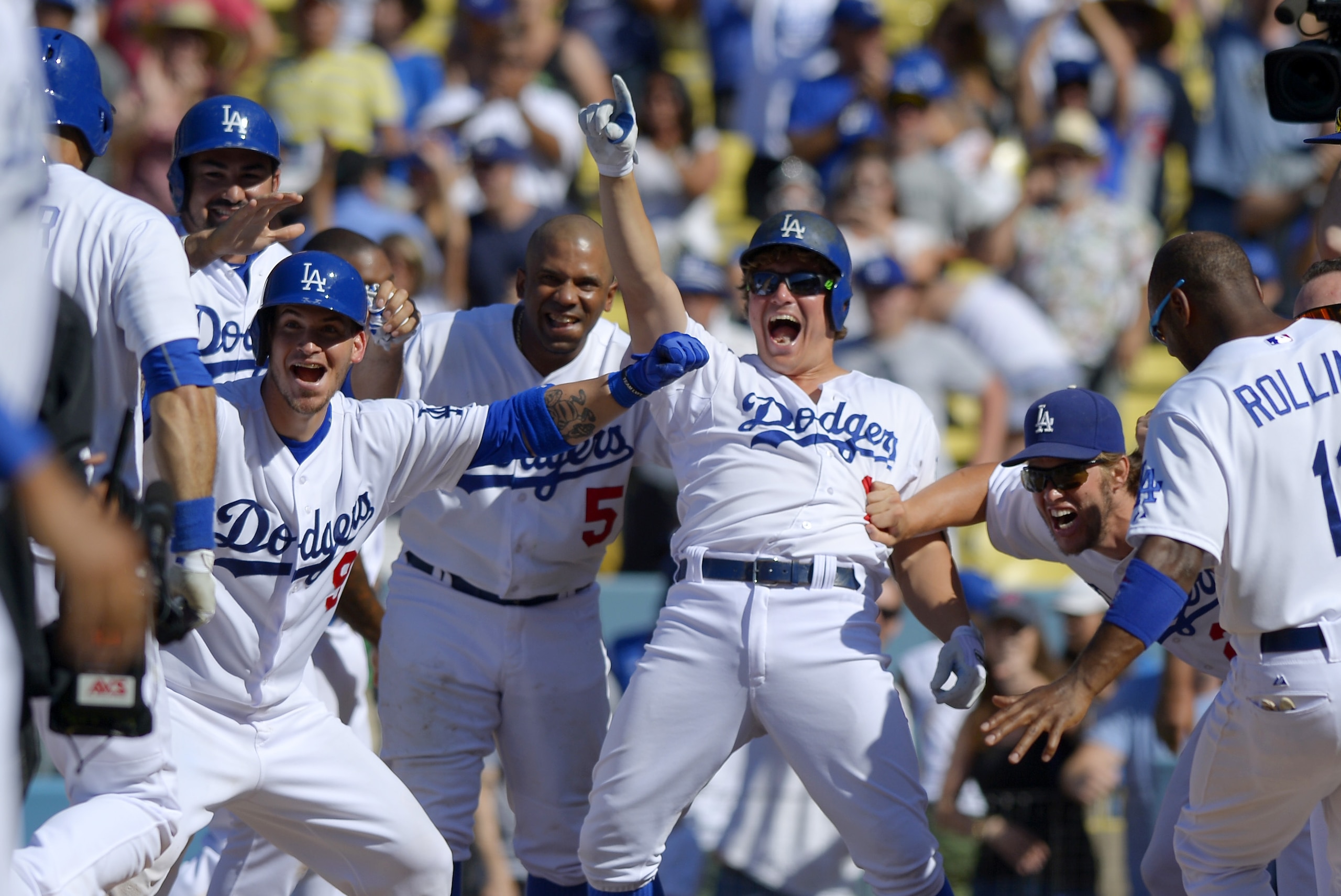 Members of the Los Angeles Dodgers wait at home plate for Andre Ethier, left, after Ethier hit a two-run home run to win the game in the 10th inning of a baseball game against the Los Angeles Angels, Sunday, Aug. 2, 2015, in Los Angeles. The Dodgers won 5-3. (AP Photo/Mark J. Terrill)