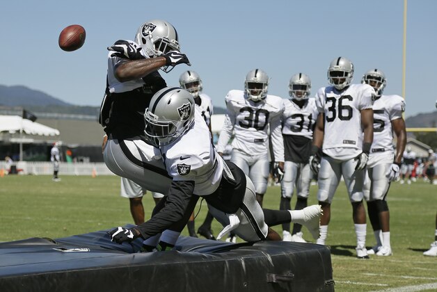 Oakland Raiders cornerbacks TJ Carrie, left, and Dexter McDonald, second from left, battle for the ball in a drill during their football training camp Monday, Aug. 3, 2015, in Napa, Calif. (AP Photo/Eric Risberg)