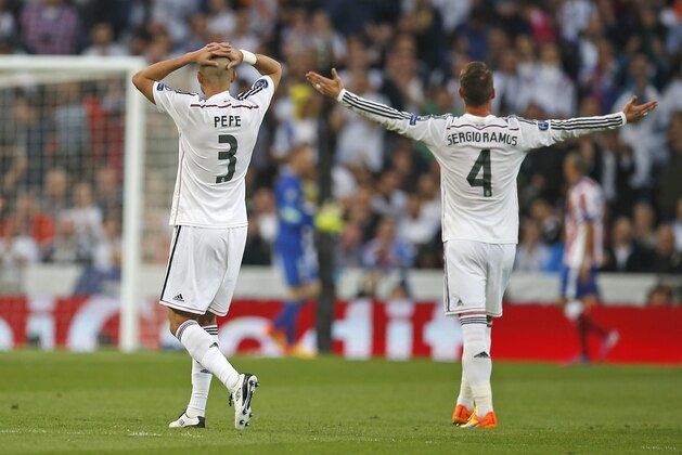 Real Madrid's Pepe, left, and Real Madrid's Sergio Ramos gestures during the second leg quarterfinal Champions League soccer match between Real Madrid and Atletico Madrid at Santiago Bernabeu stadium in Madrid, Spain, Wednesday April 22, 2015. (AP Photo/Paul White)