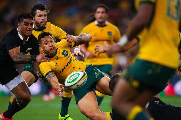 Israel Folau of Australia passes the ball against New Zealand during their Bledisloe Cup rugby match in Brisbane on October 18, 2014.  AFP PHOTO/PATRICK HAMILTON   IMAGE RESTRICTED TO EDITORIAL USE - STRICTLY NO COMMERCIAL USE        (Photo credit should read PATRICK HAMILTON/AFP/Getty Images)