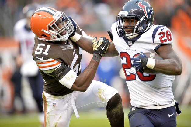 FILE - In this Nov. 16, 2014, file phot, Houston Texans running back Alfred Blue (28) fights for yardage against Cleveland Browns outside linebacker Barkevious Mingo (51) during the fourth quarter of an NFL football game in Cleveland. Blue didn't spend any time feeling sorry for himself when he didn't hear his name called until the sixth round of this year's NFL draft. Houston's rookie running back remembered something coaches had long told him: