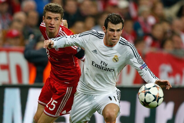 MUNICH, GERMANY - APRIL 29:  Gareth Bale (R) of Real Madrid is challenged by Thomas Mueller of Bayern Muenchen during the UEFA Champions League semi-final second leg match between FC Bayern Muenchen and Real Madrid at Allianz Arena on April 29, 2014 in Munich, Germany.  (Photo by Boris Streubel/Getty Images)