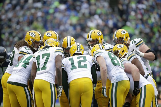 Green Bay Packers quarterback Aaron Rodgers (12) huddles up his teammates during the second half of the NFL football NFC Championship game against the Seattle Seahawks Sunday, Jan. 18, 2015, in Seattle. (AP Photo/Elaine Thompson)