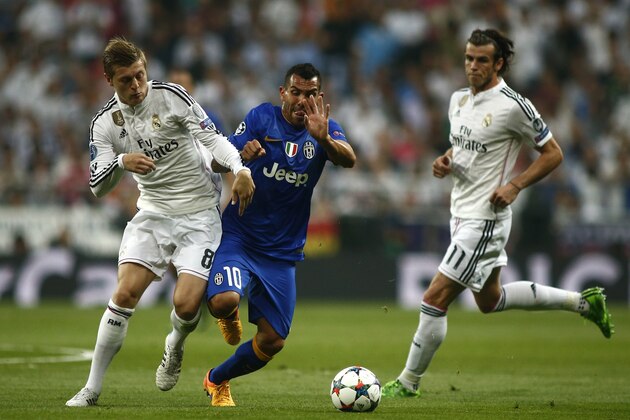 Juventus' Carlos Tevez fights for the ball against Real Madrid's Toni Kroos next to Real Madrid's Gareth Bale  during the Champions League second leg semifinal soccer match between Real Madrid and Juventus, at the Santiago Bernabeu stadium in Madrid, Wednesday, May 13, 2015.  (AP Photo/Oscar del Pozo)