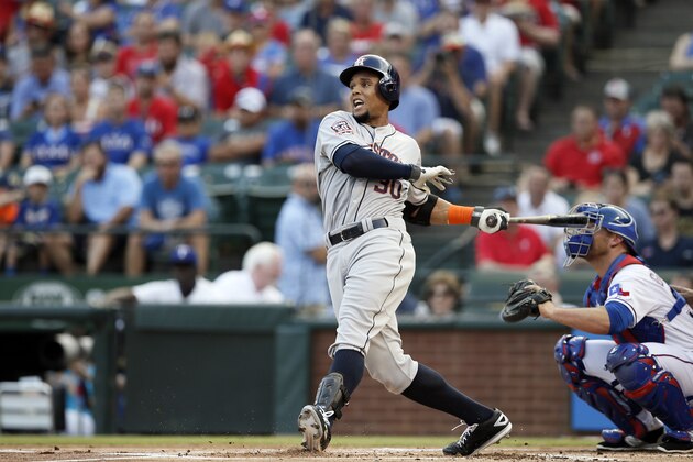 Houston Astros' Carlos Gomez (30) follows through on a swing as Texas Rangers' Chris Gimenez, right, watches in the first inning of a baseball game Tuesday, Aug. 4, 2015, in Arlington, Texas. (AP Photo/Tony Gutierrez)