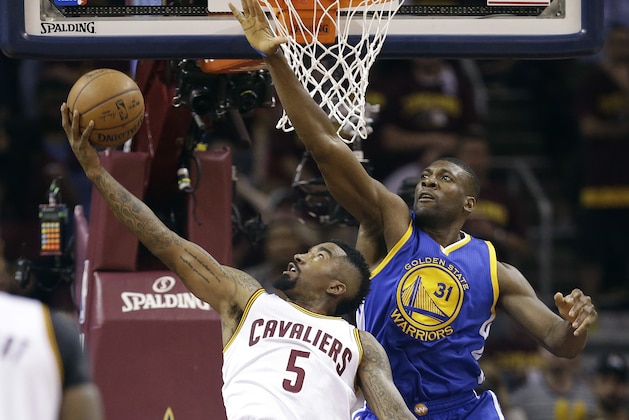 Golden State Warriors center Festus Ezeli (31) blocks the shot of Cleveland Cavaliers guard J.R. Smith (5) during the first half of Game 6 of basketball's NBA Finals in Cleveland, Tuesday, June 16, 2015. (AP Photo/Tony Dejak)