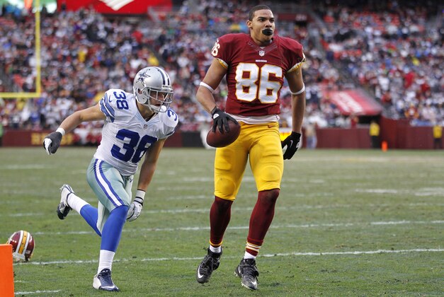 Dec 28, 2014; Landover, MD, USA; Washington Redskins tight end Jordan Reed (86) attempts to score a touchdown after having his helmet ripped of by Dallas Cowboys strong safety Jeff Heath (38) in the fourth quarter at FedEx Field. The play was ruled dead and Heath was assessed a penalty on the play. The Cowboys won 44-17. Mandatory Credit: Geoff Burke-USA TODAY Sports