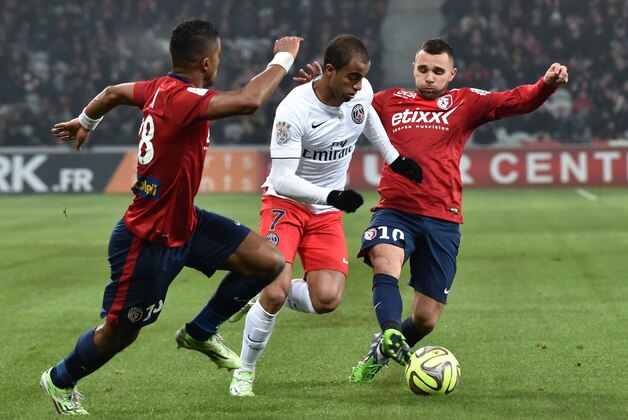 Paris Saint-Germain's Brazilian midfielder Lucas Moura (C) vies with Lille's French midfielder Marvin Martin  and Lille's Ivorian forward Salomon Kalou during their French L1 football match Lille vs PSG on December 3, 2014 at the Pierre Mauroy Stadium in Villeneuve d'Ascq, northern France.  AFP PHOTO PHILIPPE HUGUEN        (Photo credit should read PHILIPPE HUGUEN/AFP/Getty Images)