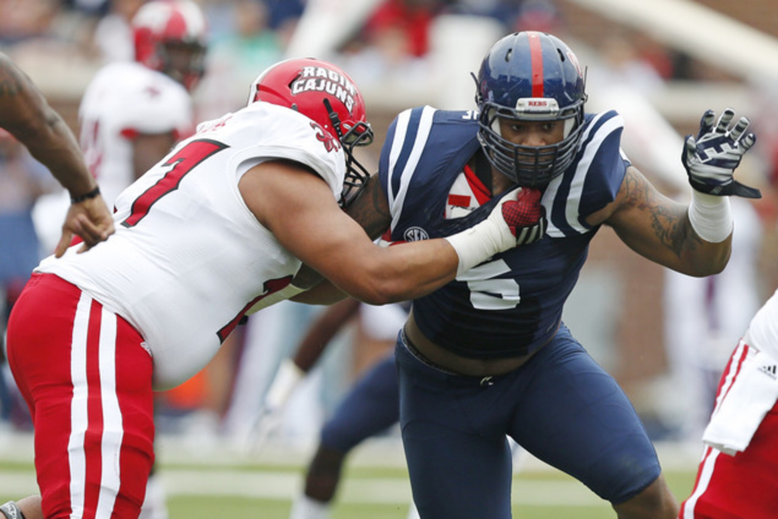 Mississippi defensive tackle Robert Nkemdiche (5) fights off a Louisiana-Lafayette offensive tackle in the first half at an NCAA college football game at Vaught-Hemingway Stadium in Oxford, Miss., Saturday, Sept. 13, 2014. No. 14 Mississippi won 56-15. (AP Photo/Rogelio V. Solis)