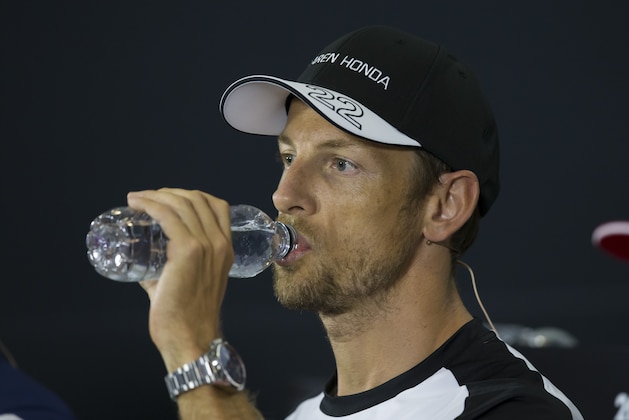 McLaren Honda driver Jenson Button from England takes a drink during a press conference before the British Formula One Grand Prix meeting at Silverstone circuit, Silverstone, England, Thursday, July 2, 2015. The British Formula One Grand Prix will be held on Sunday July 5. (AP Photo/Jon Super)