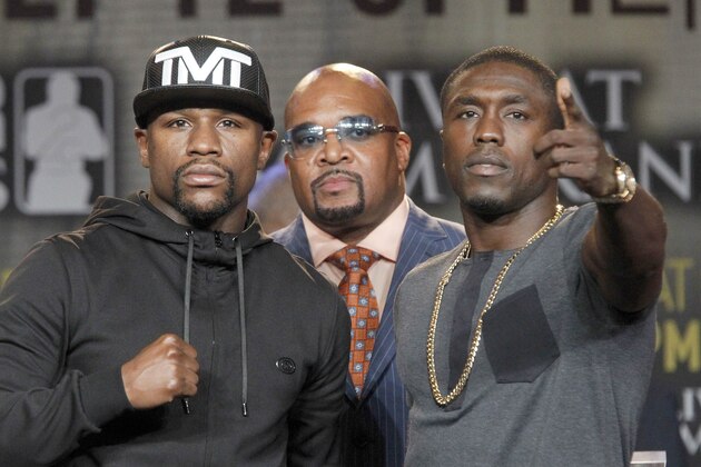 Boxers, Floyd Mayweather, Jr., left, and Andre Berto, right, pose for a photo at a news conference in Los Angeles on Thursday, Aug. 6, 2015. Mayweather Promotions, CEO Leonard Ellerbe, middle. Mayweather says Berto is a worthy opponent for the final fight of his perfect career. Three months after Mayweather dominated Manny Pacquiao in the most lucrative fight in boxing history, he began the difficult business of promoting his pay-per-view bout with Berto with a news conference in downtown Los Angeles. (AP Photo/Nick Ut)