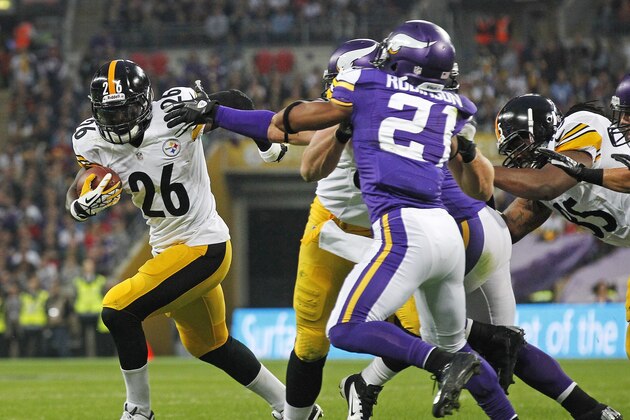 Pittsburgh Steelers running back Le'Veon Bell (26), left, tries to get away from Minnesota Vikings cornerback Josh Robinson (21) during their NFL football game at Wembley Stadium, London , Sunday, Sept. 29, 2013.  (AP Photo/Sang Tan)