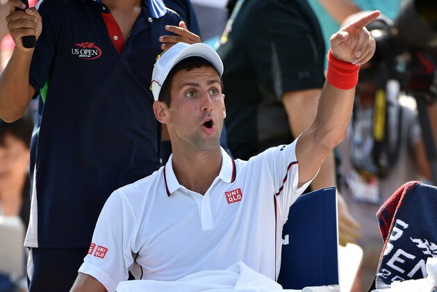 Novak Djokovic of Serbia reacts from his seat against Kei Nishikori of Japan during their 2014 US Open men's semifinal singles match at the USTA Billie Jean King National Tennis Center September 6, 2014 in New York. AFP PHOTO/Stan HONDA        (Photo credit should read STAN HONDA/AFP/Getty Images)