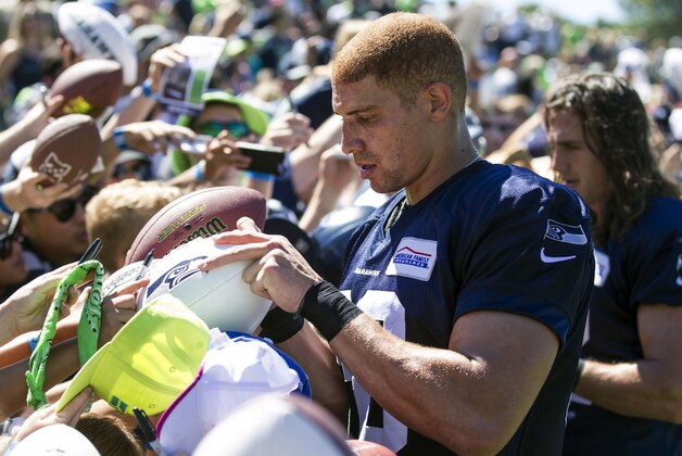 Seattle Seahawks tight end Jimmy Graham signs autographs for fans after an NFL football training camp on Friday, July 31, 2015, in Renton, Wash. (AP Photo/Stephen Brashear)