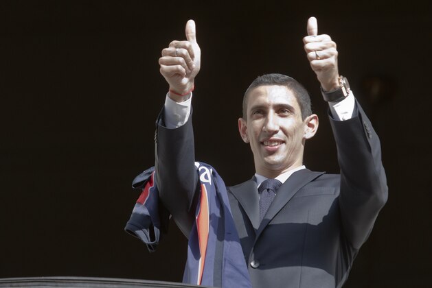 New Argentinean winger Angel Di Maria, gives the thumbs-up sign as he poses with his PSG jersey during his official presentation in Paris, France. Thursday, Aug. 6, 2015.  Angel Di Maria signed a four-year deal with Paris Saint-Germain on Thursday to complete his transfer from Manchester United. (AP Photo/Jacques Brinon)