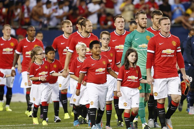 Manchester United forward Wayne Rooney, right, leads the way before an International Champions Cup soccer match against Paris Saint-Germain on Wednesday, July 29, 2015, in Chicago. (AP Photo/Kamil Krzaczynski)