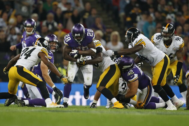 Minnesota Vikings running back Adrian Peterson (28) runs through the Pittsburgh Steelers defensive line during the second half of their NFL football game at Wembley Stadium, London, Sunday,Sept. 29, 2013. The Vikings defeated the Steelers 34-27. (AP Photo/Matt Dunham)