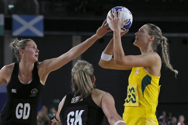Caitlin Bassett, right, of Australia lines up a shot on goal as Julie Corletto, left, attempts to block during the final of the women's Netball at the Commonwealth Games Glasgow 2014, in Glasgow, Scotland, Sunday, Aug. 3, 2014. Australia won the gold medal.(AP Photo/Alastair Grant)