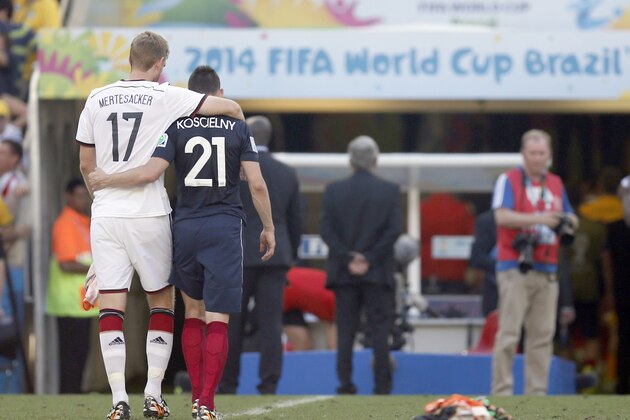 Germany's Per Mertesacker and France's Laurent Koscielny leave the pitch at the end of  the World Cup quarterfinal soccer match between Germany and France at the Maracana Stadium in Rio de Janeiro, Brazil, Friday, July 4, 2014. Germany won 1-0 to reach semi-finals. (AP Photo/Frank Augstein)