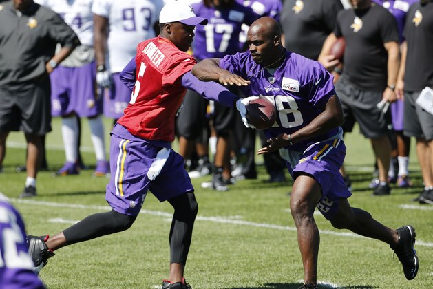 Minnesota Vikings quarterback Teddy Bridgewater hands the ball off to running back Adrian Peterson during practice at an NFL football training camp on the campus of Minnesota State University Wednesday, July 29, 2015, in Mankato, Minn. (AP Photo/Charles Rex Arbogast)