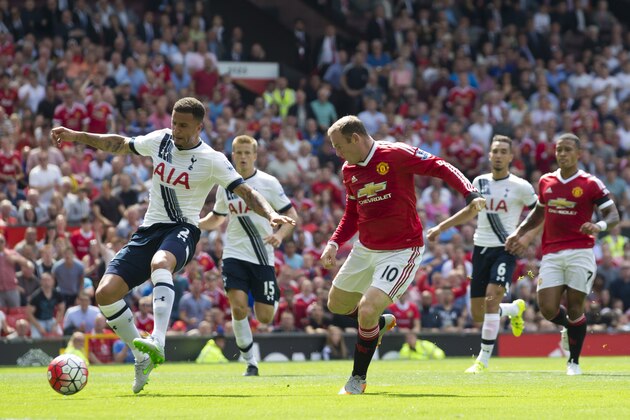 Tottenham's Kyle Walker, left, scores an own goal as he tries to clear the ball away from Manchester United's Wayne Rooney during the English Premier League soccer match between Manchester United and Tottenham at Old Trafford Stadium, Manchester, England, Saturday, Aug. 8, 2015. (AP Photo/Jon Super)