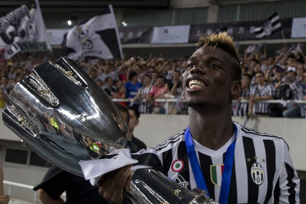 Juventus' Paul Labile Pogba celebrates with the trophy after the team won against Lazio during the 2015 TIM Italian Supercup held at the Shanghai Stadium in Shanghai, China, Saturday, Aug. 8, 2015. Juventus defeat Lazio 2-0 to win the Supercup. (AP Photo/Ng Han Guan)