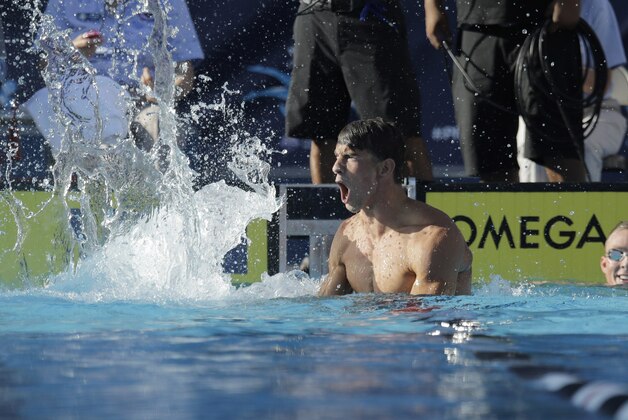 Michael Phelps slaps the water as he celebrates his win in men's 100-meter butterfly finals at the the U.S. swimming nationals, Saturday, Aug. 8, 2015, in San Antonio. (AP Photo/Eric Gay)