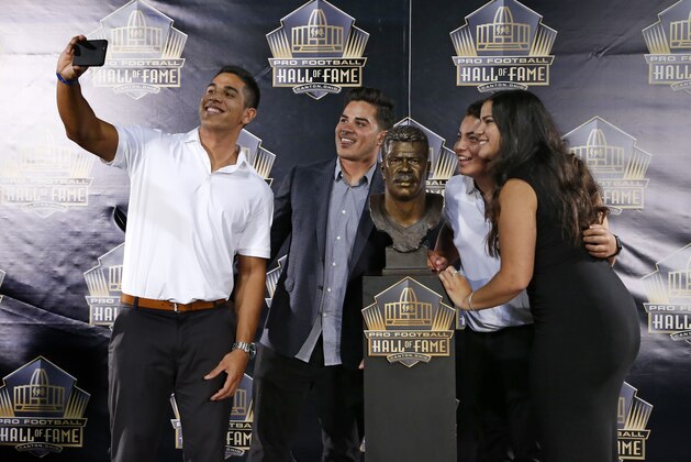 Children of former NFL player Junior Seau, from left, Jake, Tyler, Hunter, and Sydney pose for a selfie with the bust of their late father during an induction ceremony at the Pro Football Hall of Fame Saturday, Aug. 8, 2015, in Canton, Ohio.  (AP Photo/Gene J. Puskar)
