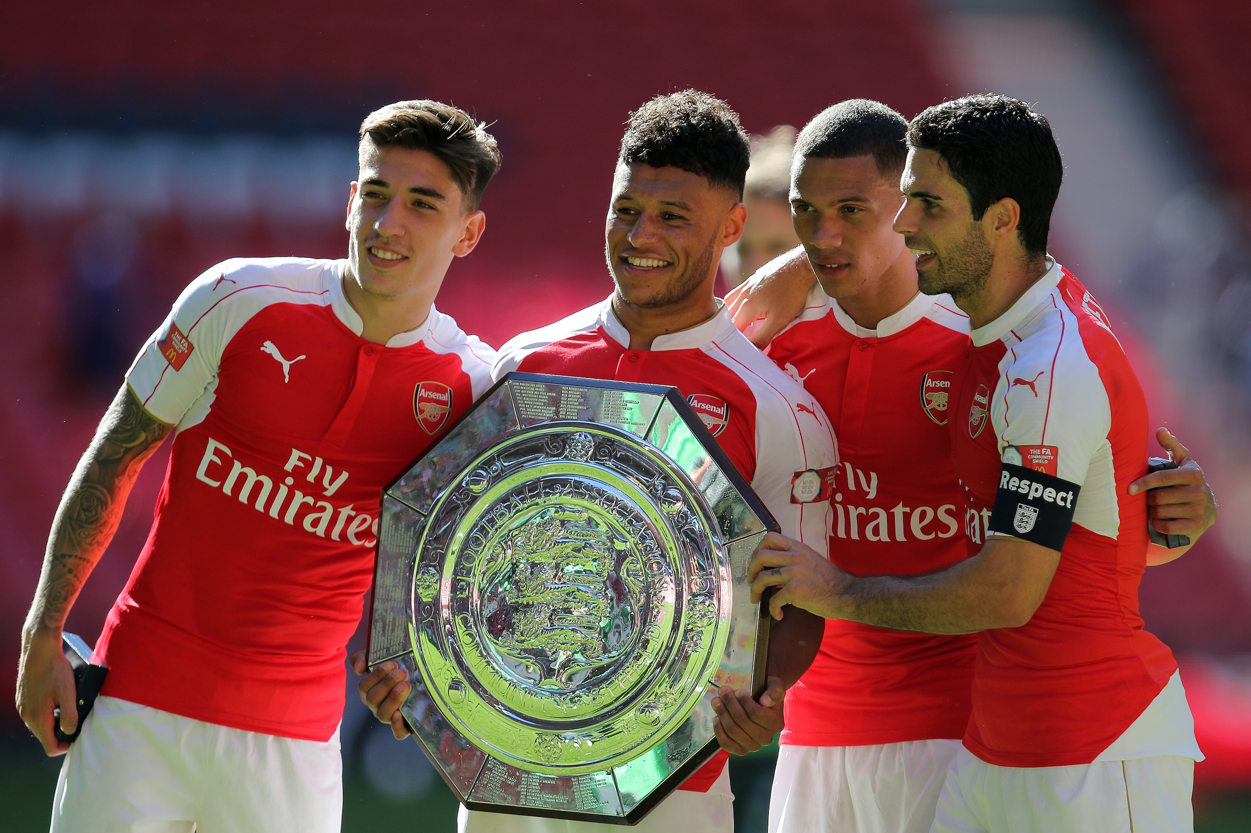 LONDON, ENGLAND -  AUGUST 2:  Arsenal goalscorer Alex Oxlade-Chamberlain celebrates with the FA Community Shield trophy with team-mates Hector Bellerin, Kieran Gibbs and Mikel Arteta after the FA Community Shield match between Chelsea and Arsenal at Wembley Stadium on August 2, 2015 in London, England.  (Photo by James Bayliss - AMA/Getty Images)