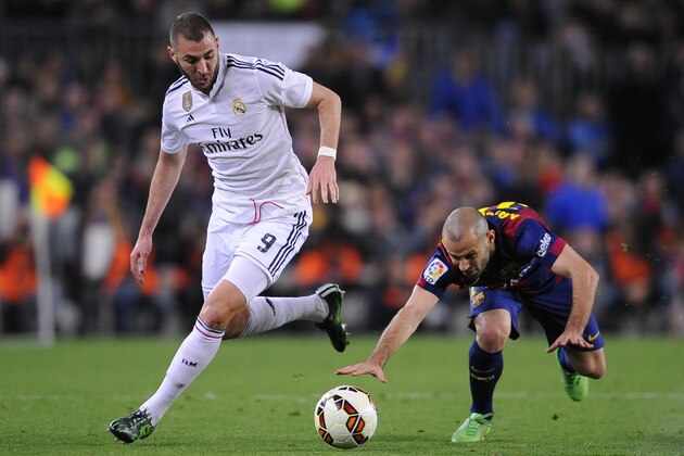 Real Madrid's Karim Benzema, left, takes the ball past Barcelona's Javier Mascherano during a Spanish La Liga soccer match between FC Barcelona and Real Madrid at Camp Nou stadium, in Barcelona, Spain, Sunday, March 22, 2015. (AP Photo/Manu Fernandez)